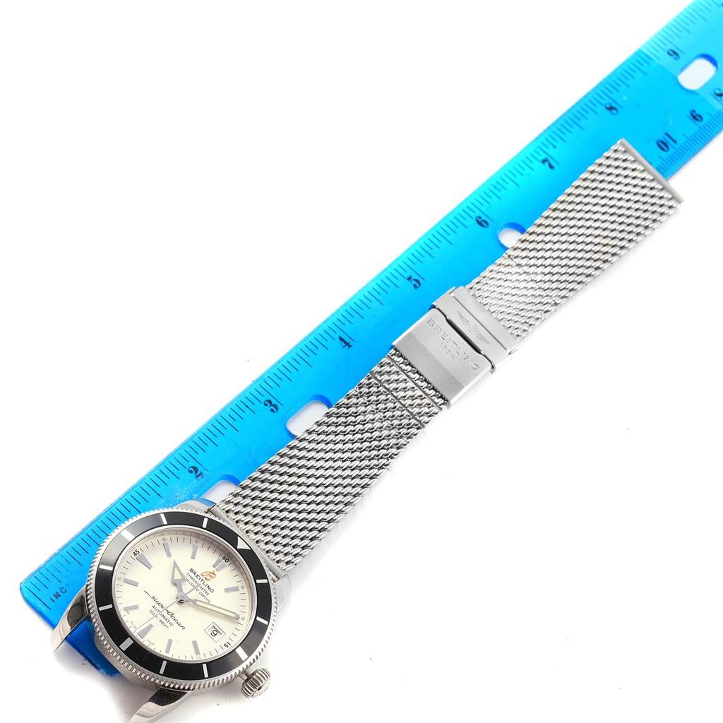 The Breitling Superocean A17321 Men's Stainless Steel White Dial A17321 Men's Stainless Steel White Dial watch is shown from an overhead angle, focusing on the dial, bezel, and mesh bracelet with clasp.