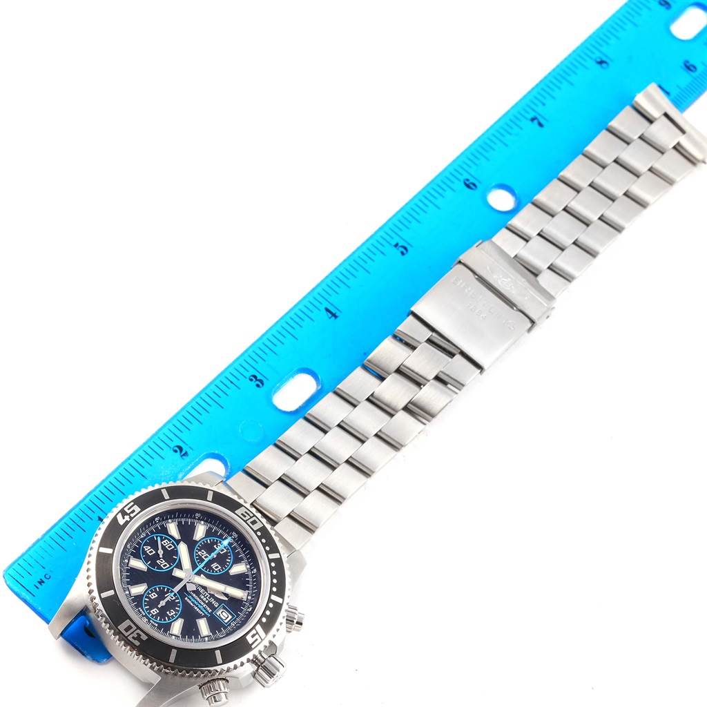 The image shows the face and stainless steel bracelet of a Breitling Superocean A13341 Men's Stainless Steel Black Dial A13341 Men's Stainless Steel Black Dial watch, placed alongside a blue ruler for measurement.