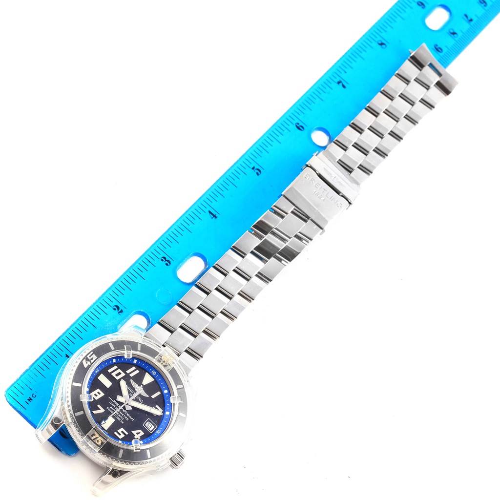 The Breitling Superocean A17364 Men's Stainless Steel Black Dial A17364 Men's Stainless Steel Black Dial watch is shown face-up with its band extended next to a ruler.