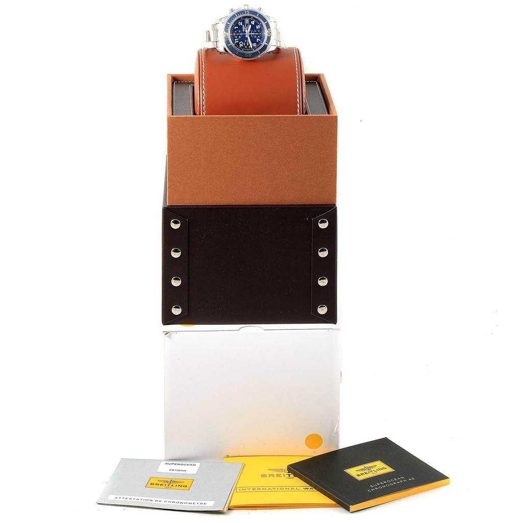 The Breitling Superocean A13311 Men's Stainless Steel Blue Dial A13311 Men's Stainless Steel Blue Dial watch is shown from the front, sitting on a pillow within an open box, with accompanying manuals displayed below.