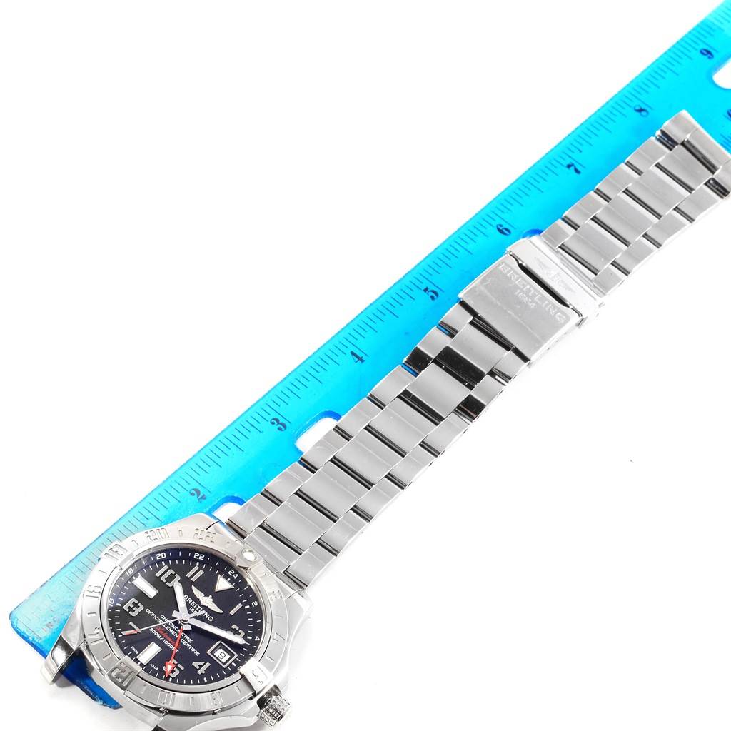 This top-down image of a Breitling Avenger A32390 Men's Stainless Steel Black Dial A32390 Men's Stainless Steel Black Dial watch shows the watch face, bezel, bracelet, and clasp alongside a ruler for scale.