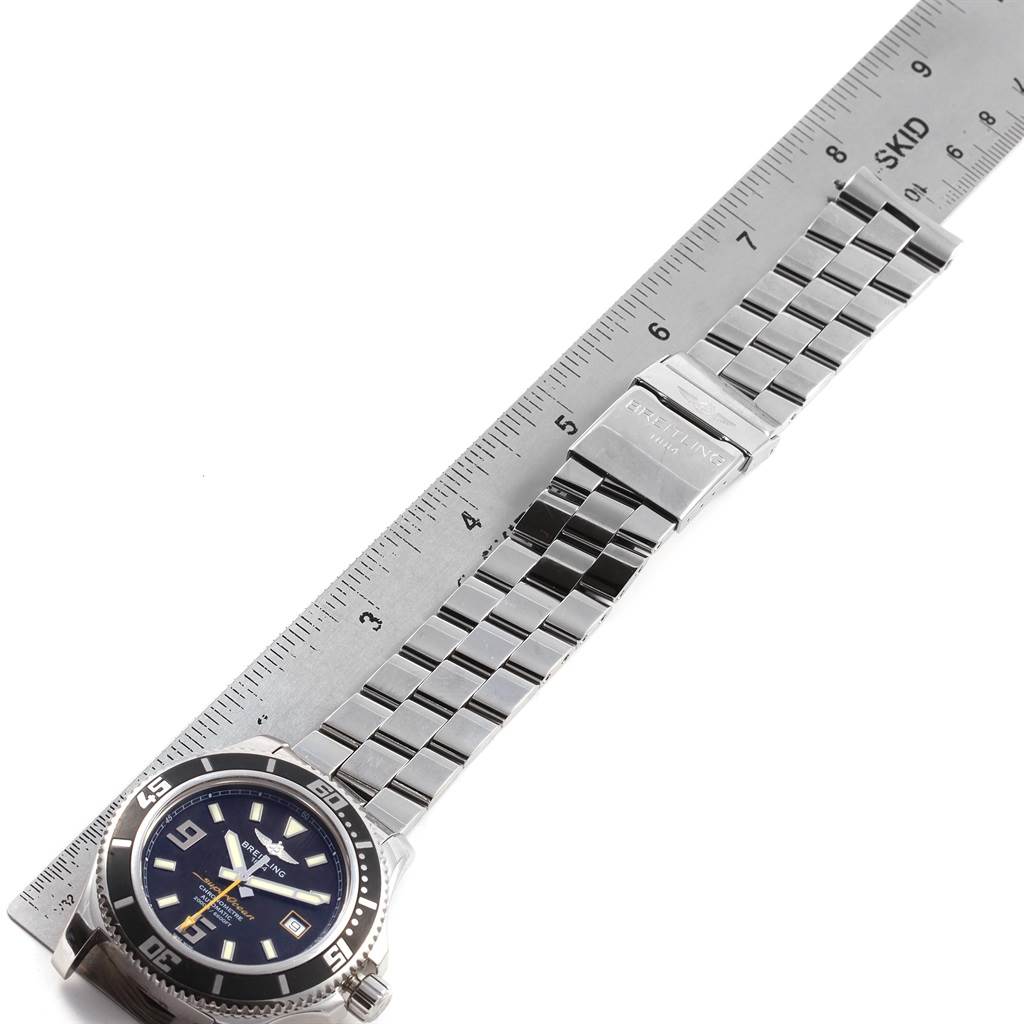 The image shows a Breitling Superocean A17391 Men's Stainless Steel Black Dial A17391 Men's Stainless Steel Black Dial watch laid flat next to a ruler, displaying the face and stainless steel bracelet.