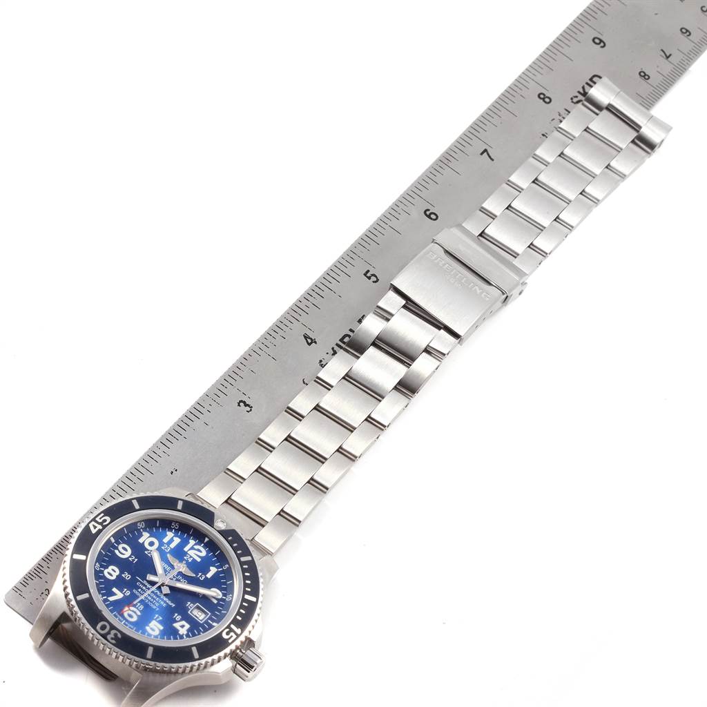 The image shows the Breitling Superocean A17392 Men's Stainless Steel Blue Dial A17392 Men's Stainless Steel Blue Dial watch laid flat, featuring its blue dial, bezel, and metal bracelet, with a ruler for scale.