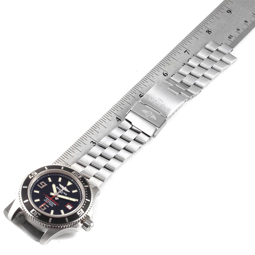The image shows a Breitling Superocean A17391 Men's Stainless Steel Black Dial A17391 Men's Stainless Steel Black Dial watch on its side, highlighting the bracelet and clasp alongside a ruler.