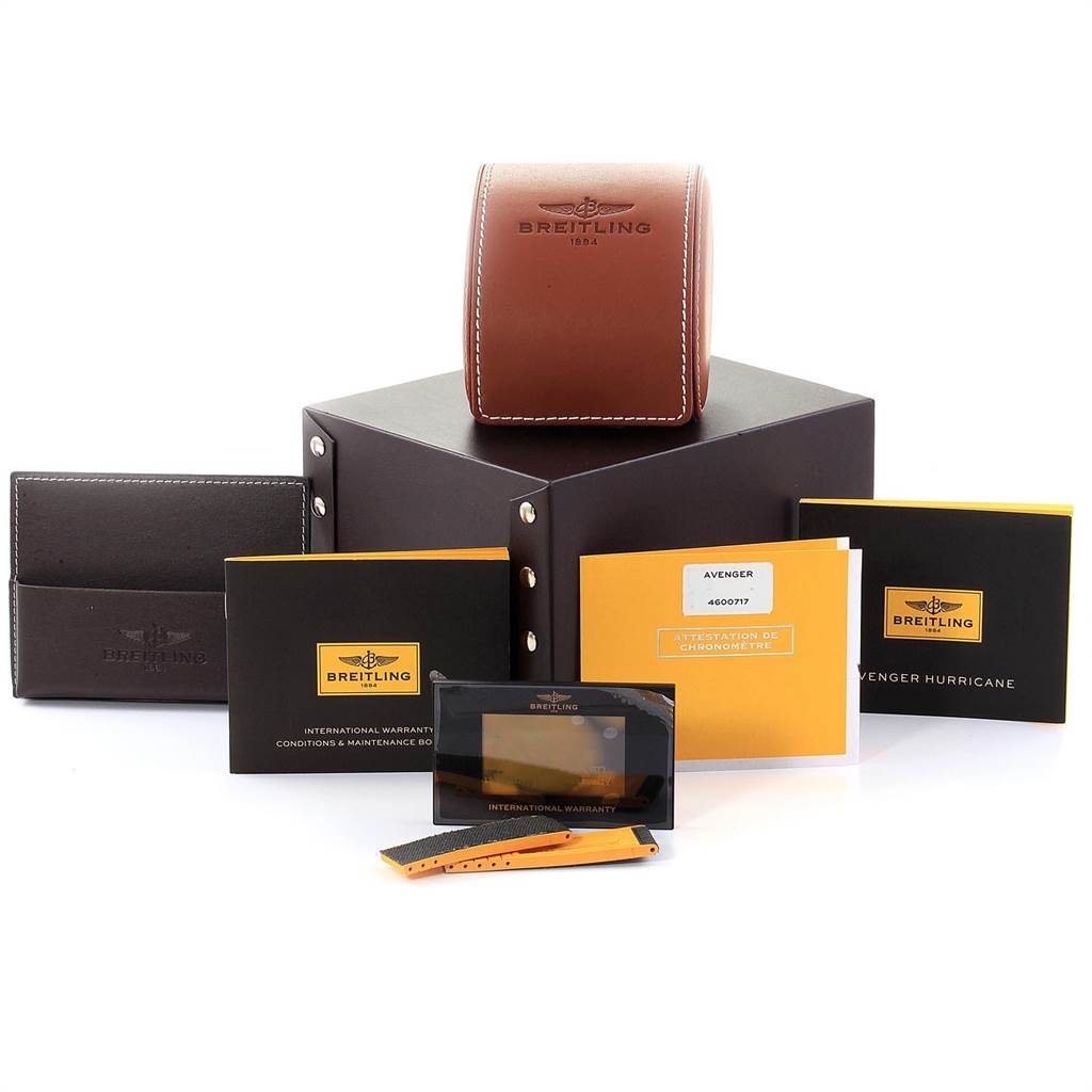 The image shows various accessories of a Breitling Avenger XB1210E4/BE89-257S Men's Titanium Black Dial XB1210E4/BE89-257S Men's Titanium Black Dial watch, including manuals, warranty cards, and a leather carrying case.