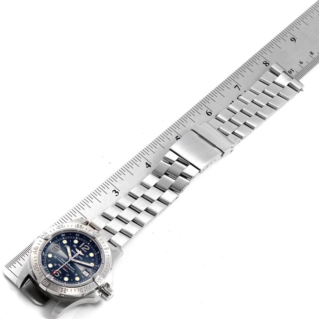 The Breitling Superocean A17390 Men's Stainless Steel Blue Dial A17390 Men's Stainless Steel Blue Dial watch is displayed at an angle, showing the face, bezel, bracelet, and clasp on a measuring ruler.