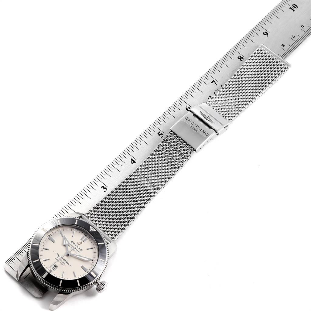 The image shows a Breitling Superocean AB2020 Men's Stainless Steel Silver Dial AB2020 Men's Stainless Steel Silver Dial watch with a mesh bracelet and deployant clasp, displayed alongside a ruler.
