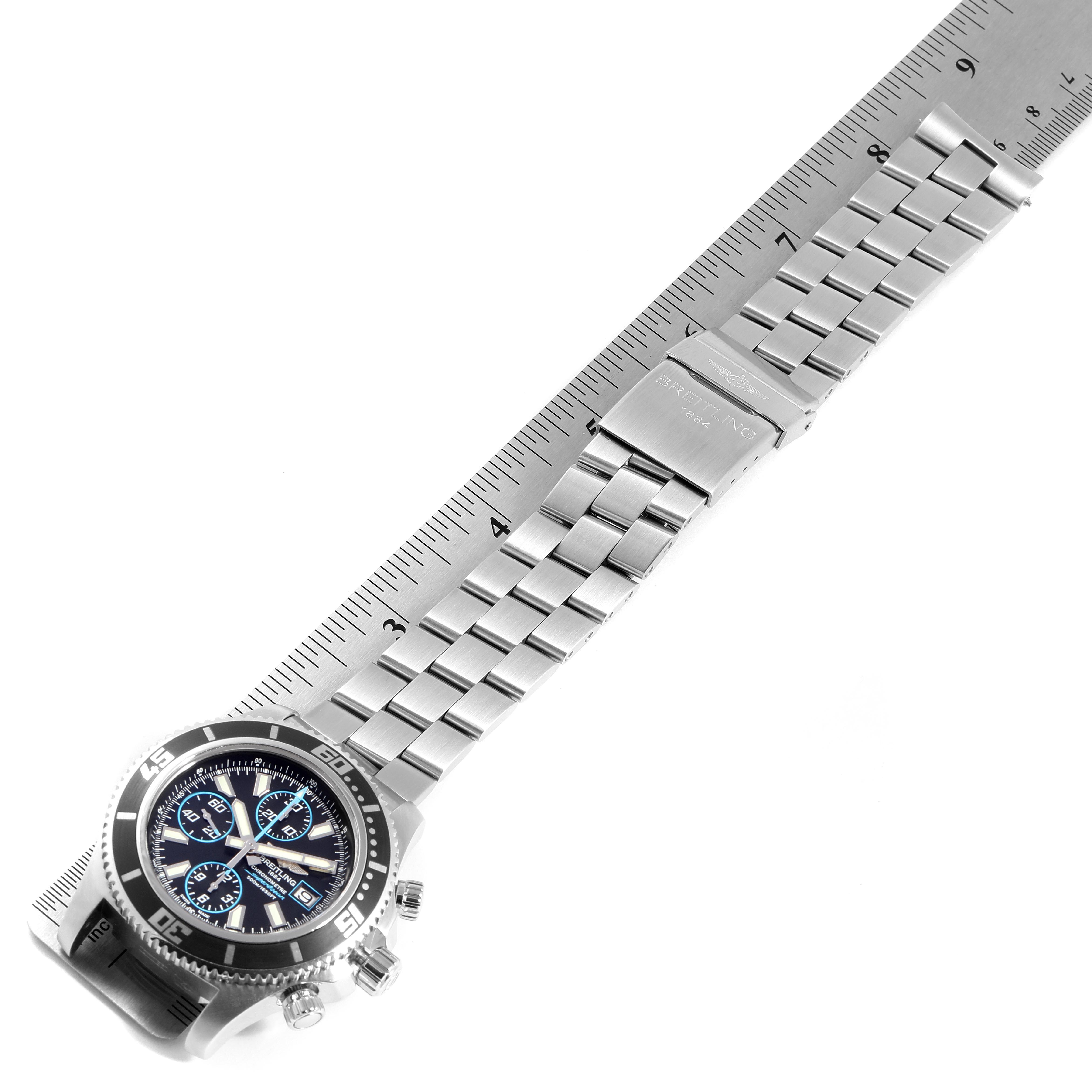 This image shows the Breitling Superocean A13341 Men's Stainless Steel Black Dial A13341 Men's Stainless Steel Black Dial watch at an angled view, highlighting its face, bezel, and metal bracelet against a measuring ruler.