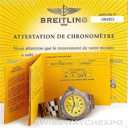 The image shows a Breitling Avenger E17370 Men's Titanium Yellow Dial E17370 Men's Titanium Yellow Dial watch with yellow dial and warranty certificates placed around it.