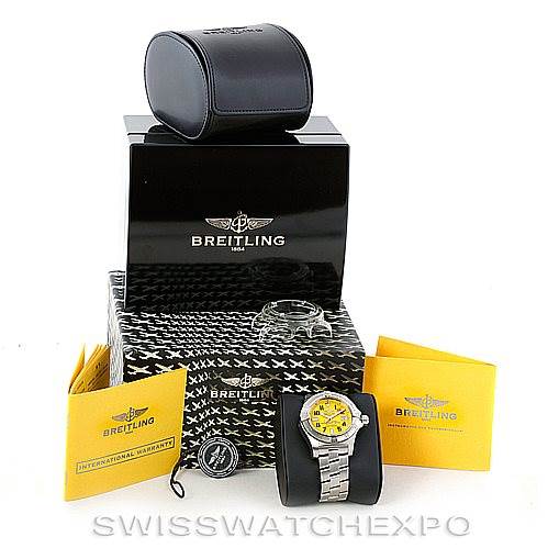 The image shows a Breitling Avenger A17330 Men's Stainless Steel Yellow Dial A17330 Men's Stainless Steel Yellow Dial watch with its box, warranty papers, and a black travel case from a frontal angle.