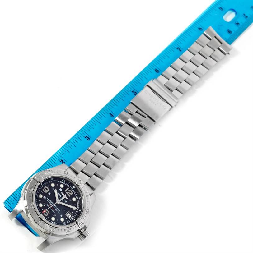 The Breitling Superocean A17390 Men's Stainless Steel Black Dial A17390 Men's Stainless Steel Black Dial watch is shown from above, displaying the face, bezel, and metal bracelet alongside a blue ruler.