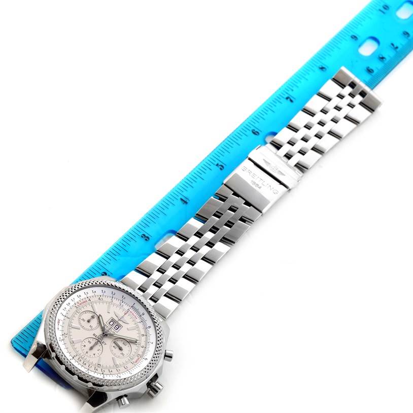 The image shows a top view of a Breitling Bentley A44362 Men's Stainless Steel Silver Dial A44362 Men's Stainless Steel Silver Dial watch alongside a blue ruler, displaying the face and metal bracelet.