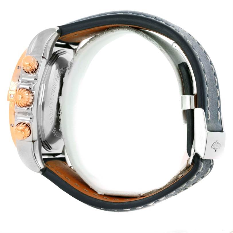 The image shows a side view of a Breitling Chronomat CB0110 Men's Steel and Gold (two tone) Blue Dial CB0110 Men's Steel and Gold (two tone) Blue Dial watch highlighting its crown, chronograph pushers, and leather strap.