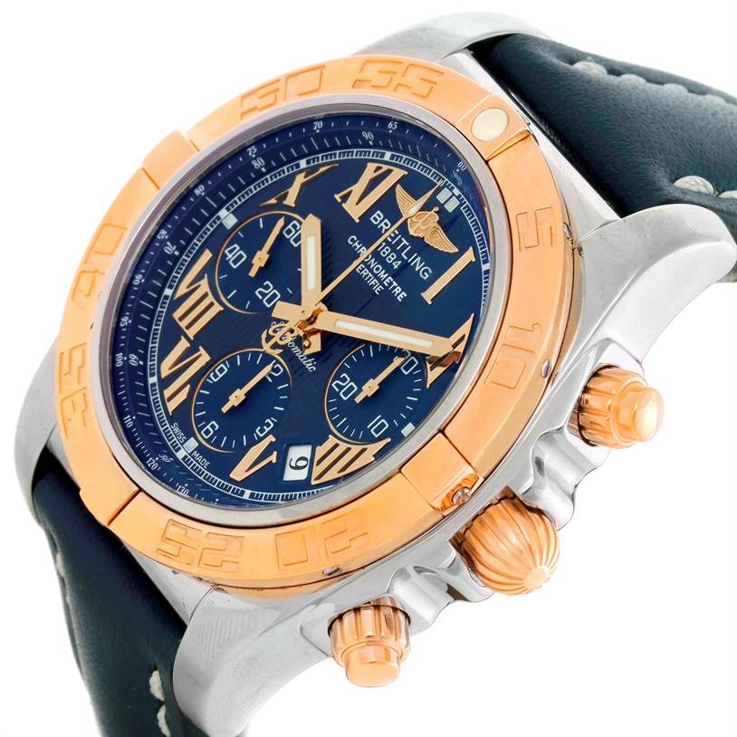 The image shows a side-angle view of the Breitling Chronomat CB0110 Men's Steel and Gold (two tone) Blue Dial CB0110 Men's Steel and Gold (two tone) Blue Dial watch, highlighting its bezel, crown, chronograph pushers, and part of the leather strap.