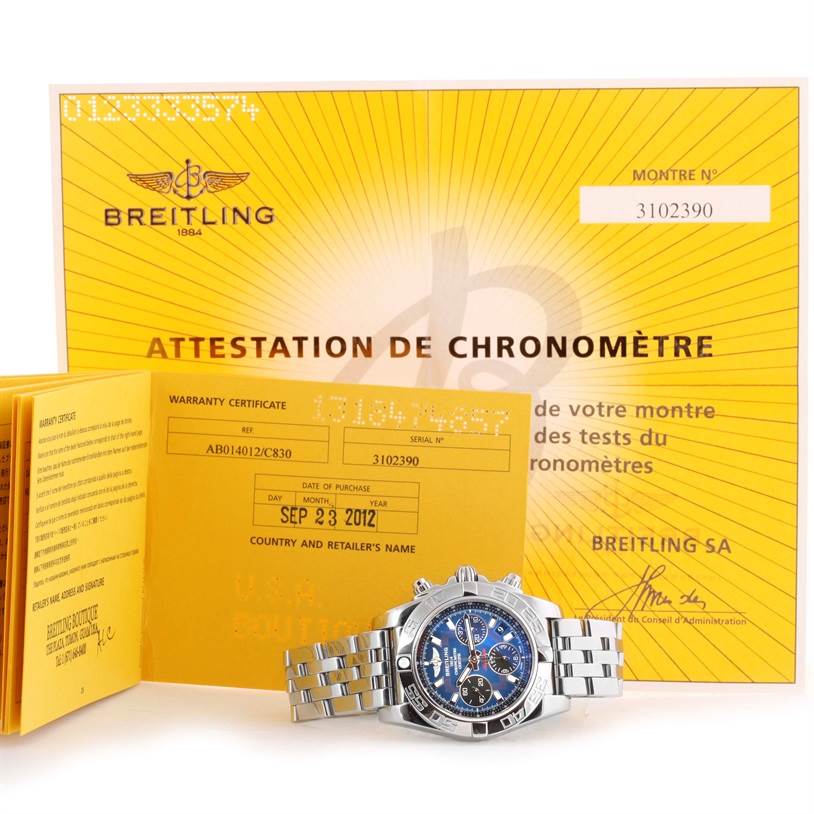 The image shows a Breitling Chronomat AB0410 Men
s Stainless Steel Blue Dial AB0410 Men
s Stainless Steel Blue Dial watch with its stainless steel bracelet, warranty certificate, and chronometer certificate.