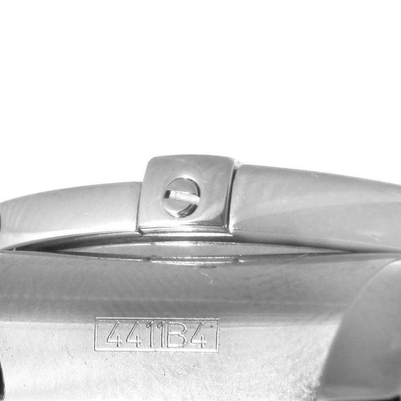 The image shows a close-up of the side of a Breitling Chronomat AB0410 Men
s Stainless Steel Blue Dial AB0410 Men
s Stainless Steel Blue Dial watch, highlighting a screw and some serial markings.