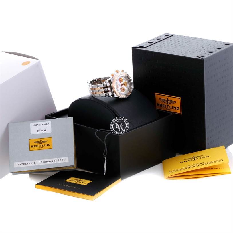 The image shows a Breitling Chronomat CB014012-G713-378C Men
s Steel and Gold (two tone) White Dial CB014012-G713-378C Men
s Steel and Gold (two tone) White Dial watch at an angle, along with its packaging and documentation.