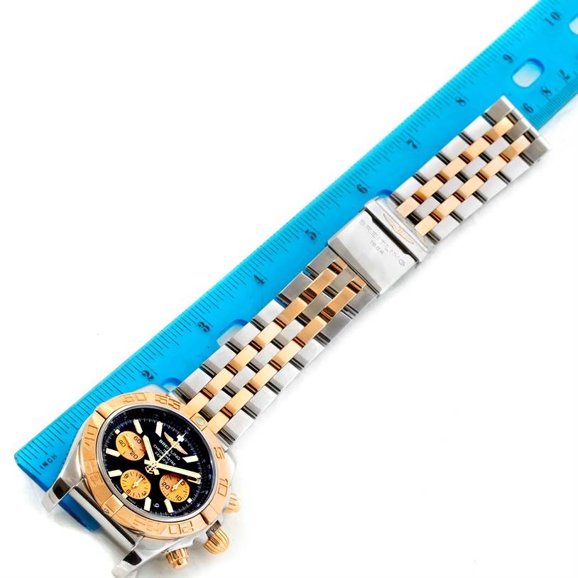 This image shows a Breitling Chronomat CB0110 Men's Steel and Gold (two tone) Black Dial CB0110 Men's Steel and Gold (two tone) Black Dial watch at a top-down angle, featuring the watch face, bezel, and bracelet alongside a ruler for scale.