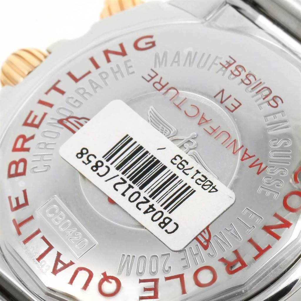 The image shows the back case of a Breitling Chronomat CB042012/C858 Men's Steel and Gold (two tone) Blue Dial CB042012/C858 Men's Steel and Gold (two tone) Blue Dial watch, featuring branding details and a barcode sticker.