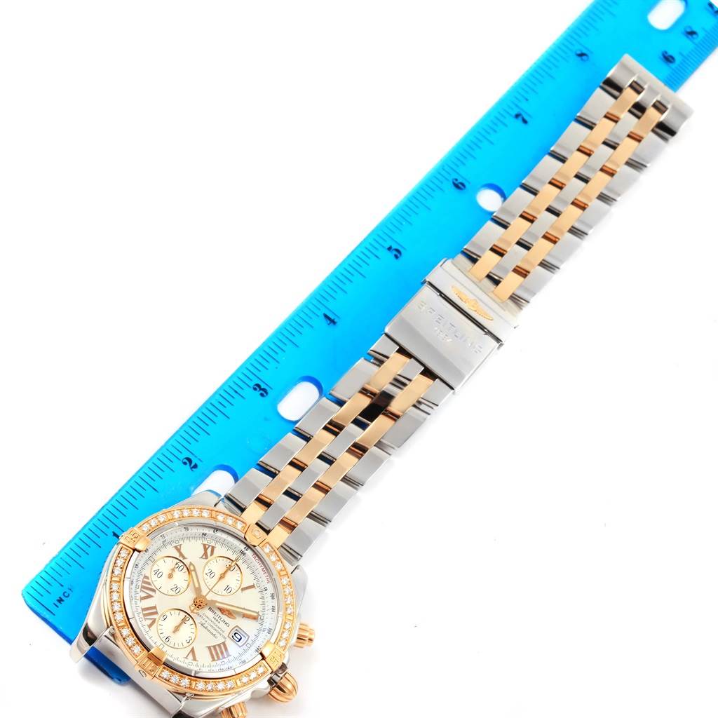 This image shows a top-down view of a Breitling Chronomat C13356 Men's Steel and Gold (two tone) White Dial C13356 Men's Steel and Gold (two tone) White Dial watch, displaying the dial, bezel, and bracelet beside a ruler.