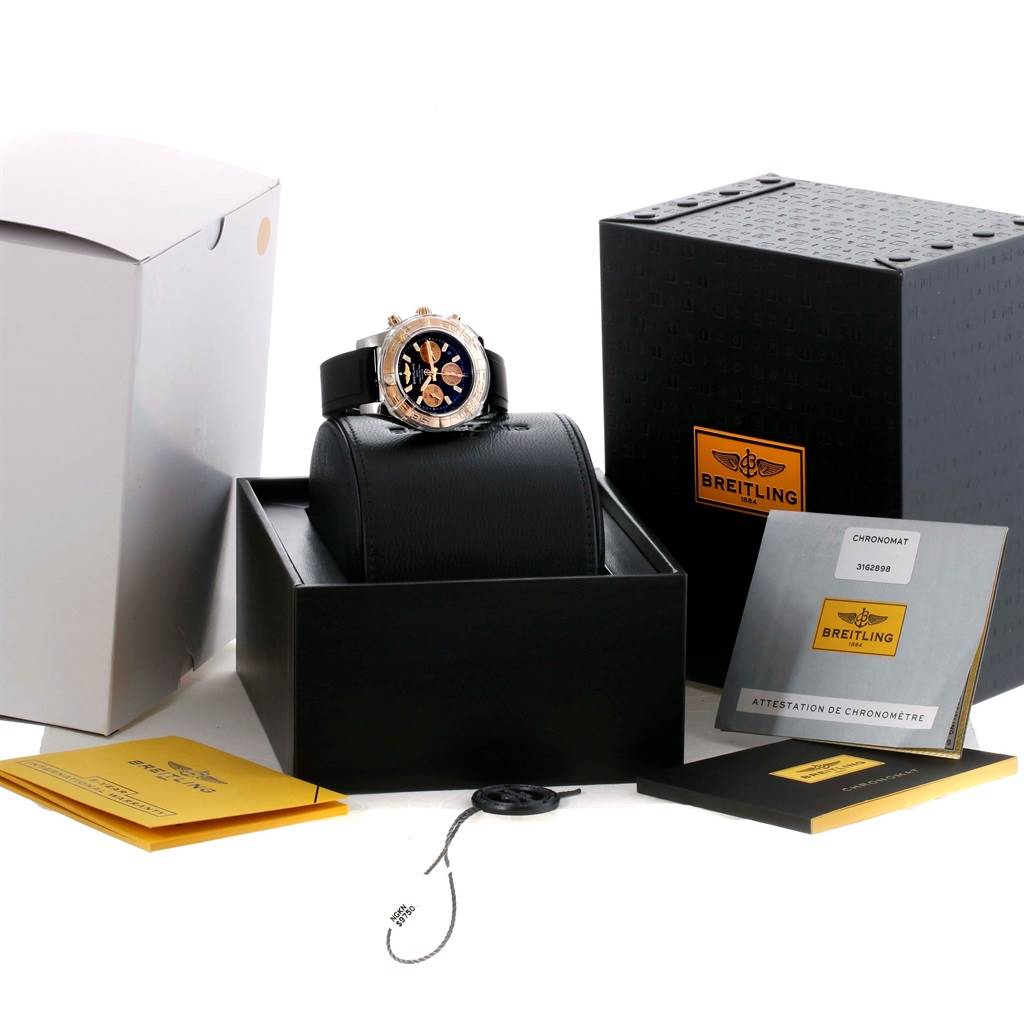 The Breitling Chronomat CB0140 Men's Steel and Gold (two tone) Black Dial CB0140 Men's Steel and Gold (two tone) Black Dial watch is shown from a front angle with its box, instruction manual, and authenticity papers.