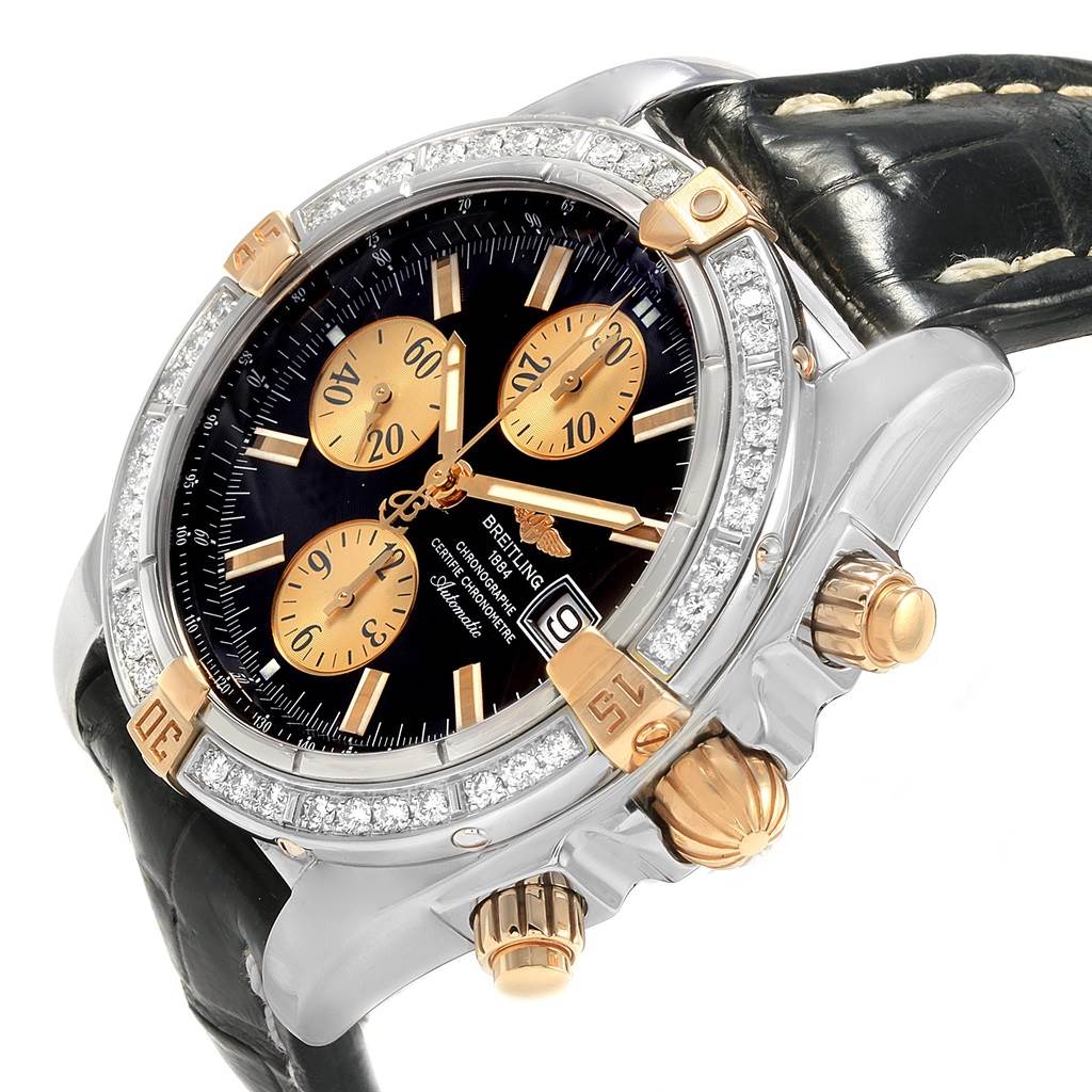 The image shows a Breitling Chronomat B13356 Men's Steel and Gold (two tone) Black Dial B13356 Men's Steel and Gold (two tone) Black Dial watch from an angled side view, highlighting its face, bezel, crown, pushers, and part of the leather strap.