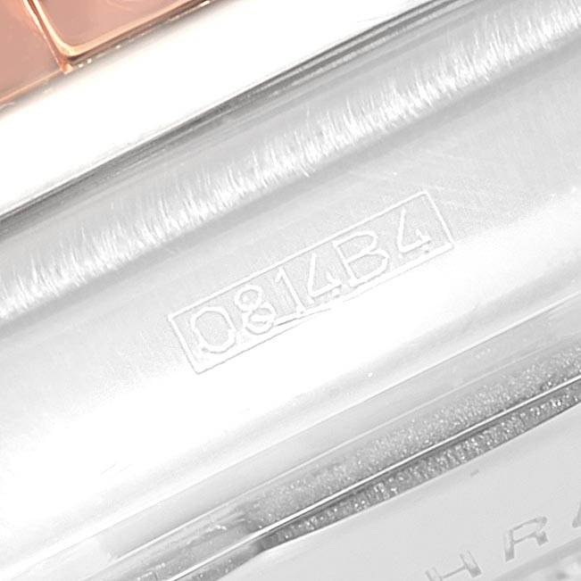 The image shows a close-up angle of the case side of a Breitling Chronomat CB0110 Men
s Steel and Gold (two tone) Blue Dial CB0110 Men
s Steel and Gold (two tone) Blue Dial watch, featuring part of the bracelet and serial number.