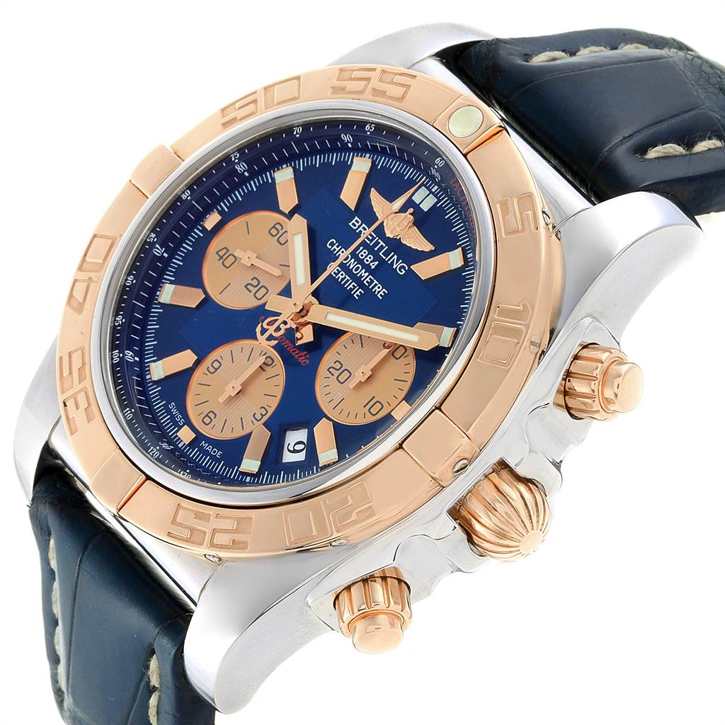 This Breitling Chronomat CB0110 Men
s Steel and Gold (two tone) Blue Dial CB0110 Men
s Steel and Gold (two tone) Blue Dial watch is shown from an oblique angle, highlighting the dial, bezel, pushers, crown, and leather strap.