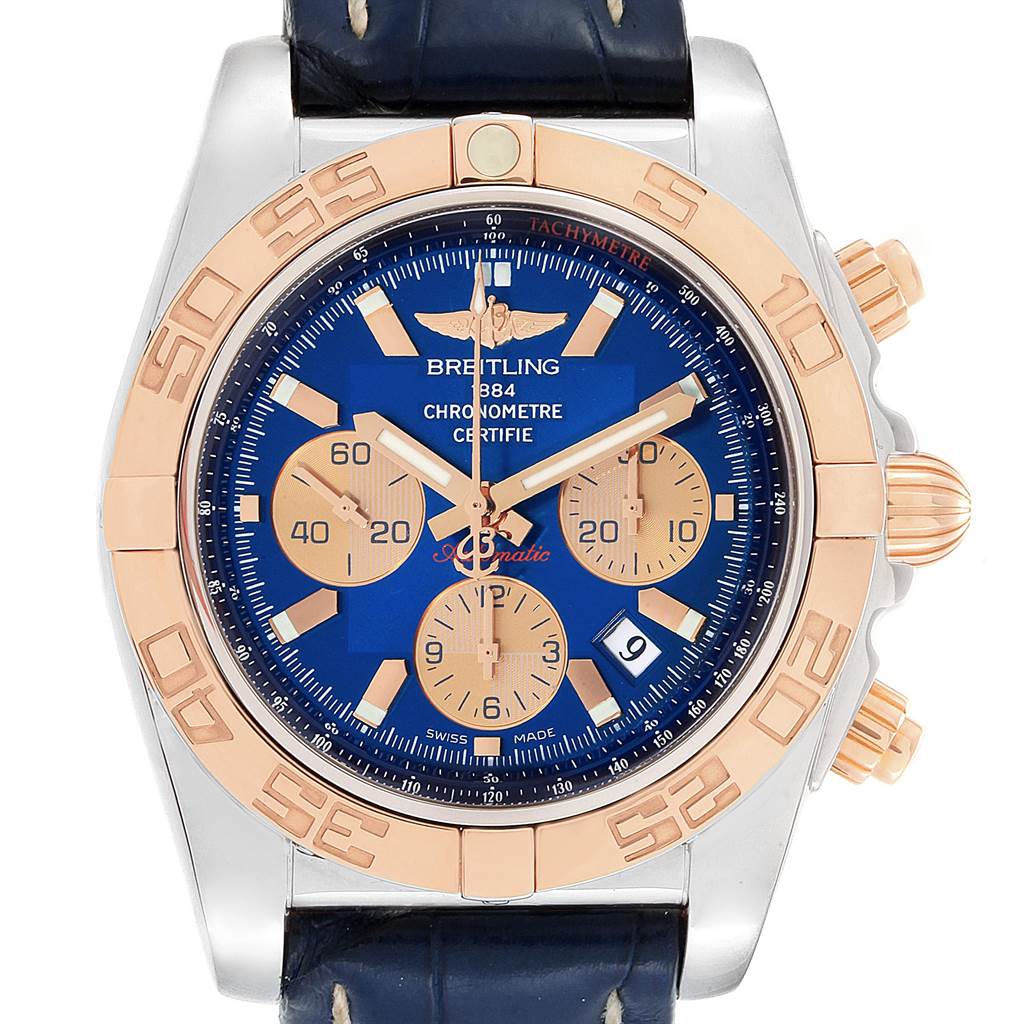 The Breitling Chronomat CB0110 Men
s Steel and Gold (two tone) Blue Dial CB0110 Men
s Steel and Gold (two tone) Blue Dial watch is shown from a front angle, highlighting its blue dial, gold subdials, and bezel with tachymeter scale.
