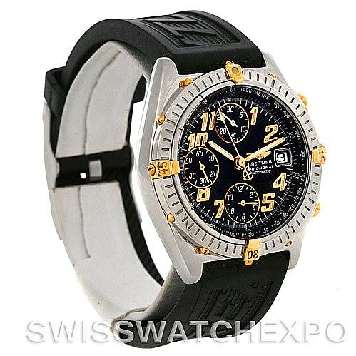 The image shows a Breitling Chronomat B13350 Men's Steel and Gold (two tone) Black Dial B13350 Men's Steel and Gold (two tone) Black Dial watch at an oblique angle, highlighting the dial and rubber strap.