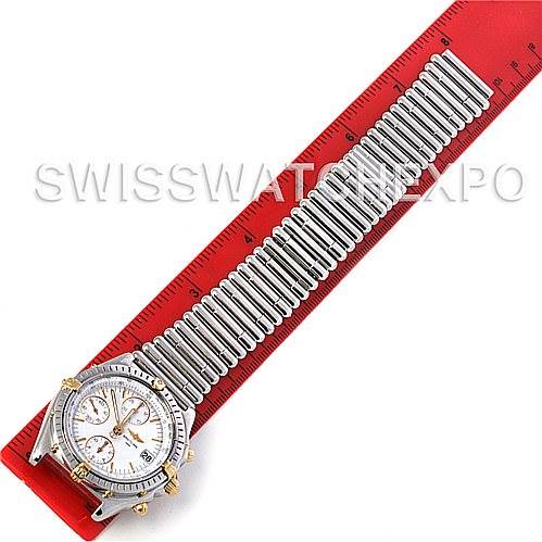 The image shows a top view of a Breitling Chronomat B13050 Men's Steel and Gold (two tone) White Dial B13050 Men's Steel and Gold (two tone) White Dial watch with its band laid straight next to a red ruler for measurement.