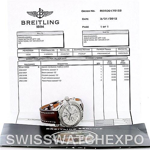 The image shows a Breitling Chronomat A13356 Men's Stainless Steel Silver Dial A13356 Men's Stainless Steel Silver Dial watch at an angled view with its accompanying service documents in the background.