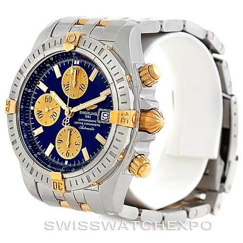 The image shows a side-angle view of a Breitling Chronomat B13356 Men
s Steel and Gold (two tone) Blue Dial B13356 Men
s Steel and Gold (two tone) Blue Dial watch, highlighting its bezel, crown, and chronograph subdials.