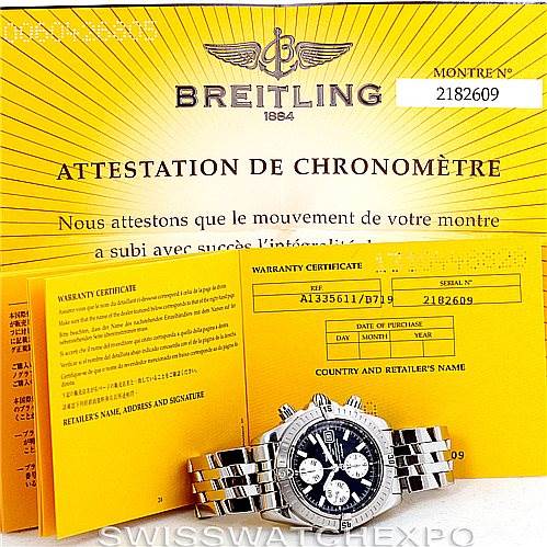The image shows the Breitling Chronomat A13356 Men
s Stainless Steel Black Dial A13356 Men
s Stainless Steel Black Dial watch along with its warranty certificate and chronometer attestation, all placed at an angle.