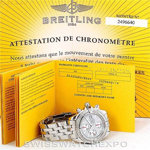 The image shows a Breitling Chronomat A13356 Men's Stainless Steel Silver Dial A13356 Men's Stainless Steel Silver Dial watch lying flat with its warranty certificate and chronometer certificate behind it.