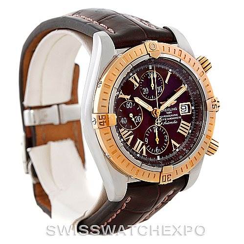 The image shows a side angle of a Breitling Chronomat C13356 Men's Steel and Gold (two tone) Burgundy Dial C13356 Men's Steel and Gold (two tone) Burgundy Dial watch, highlighting its brown leather strap, gold bezel, and detailed dial.