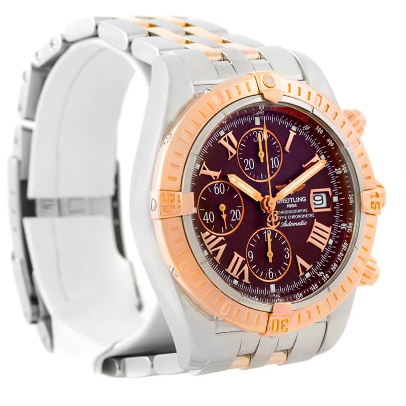 The image shows a Breitling Chronomat C13356 Men's Steel and Gold (two tone) Burgundy Dial C13356 Men's Steel and Gold (two tone) Burgundy Dial watch at an angled view, highlighting its face, bezel, and part of the metal bracelet.