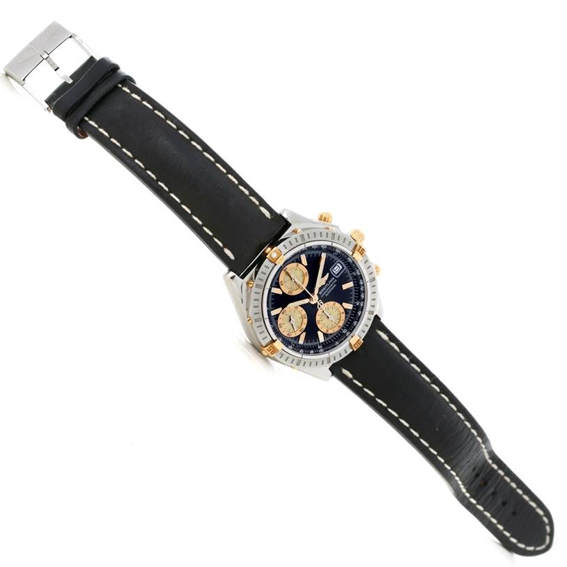 The Breitling Chronomat B13352 Men
s Steel and Gold (two tone) Black Dial B13352 Men
s Steel and Gold (two tone) Black Dial watch is shown from an angled top view, highlighting the face, bezel, crown, and leather strap.