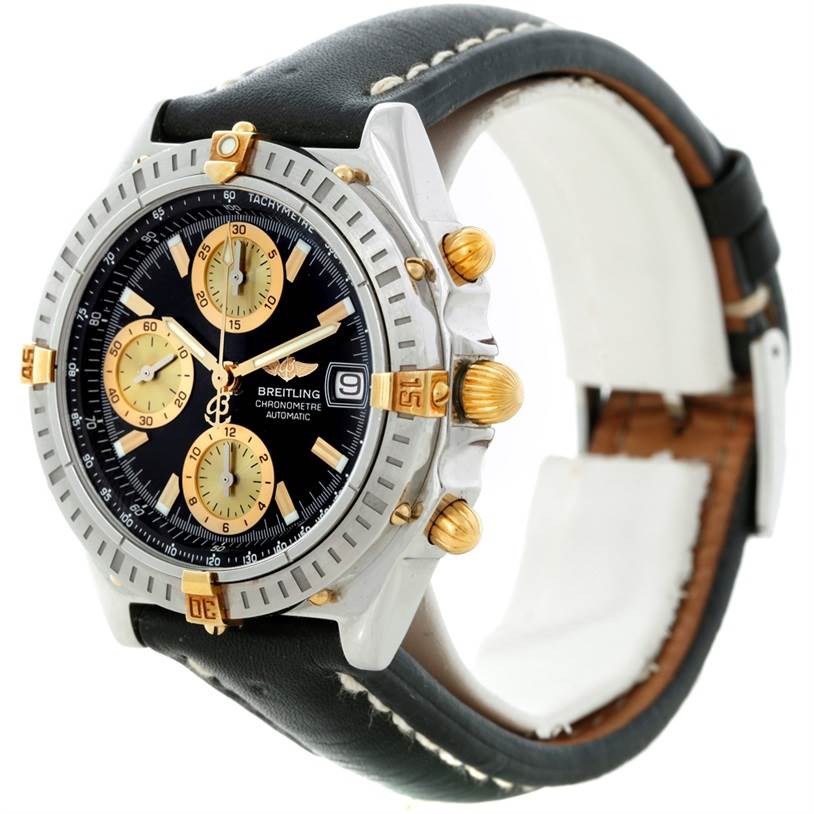 The image shows a side angle of the Breitling Chronomat B13352 Men
s Steel and Gold (two tone) Black Dial B13352 Men
s Steel and Gold (two tone) Black Dial watch, highlighting its face, bezel, crown, and leather strap.