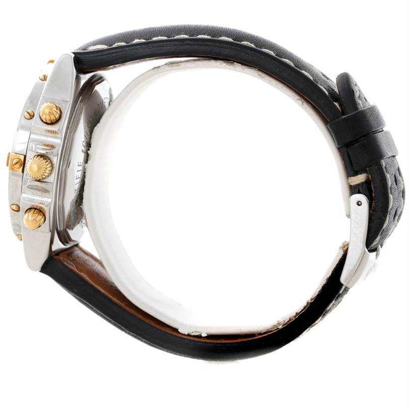 The image shows a Breitling Chronomat B13352 Men
s Steel and Gold (two tone) Black Dial B13352 Men
s Steel and Gold (two tone) Black Dial watch from the side, highlighting the bezel, crown, pushers, and black leather strap.