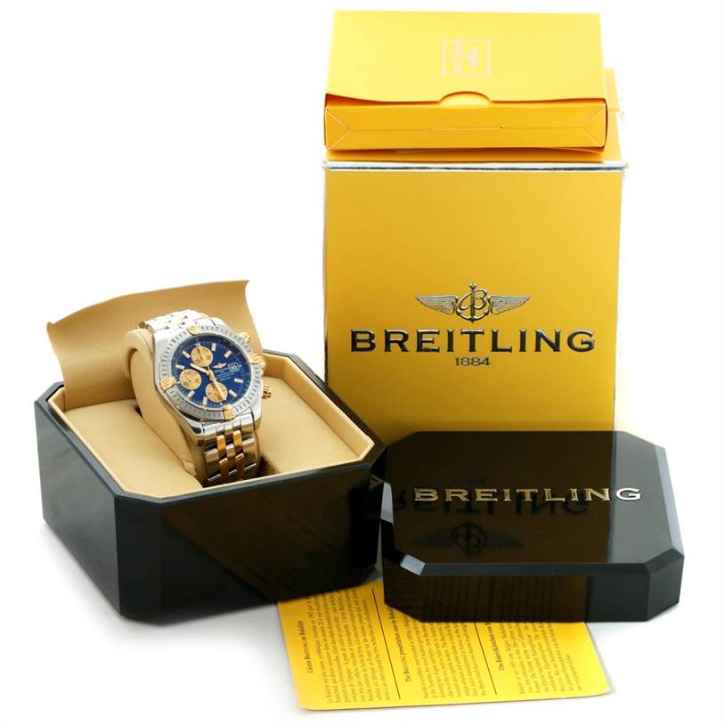 The image shows a Breitling Chronomat B13356 Men's Steel and Gold (two tone) Blue Dial B13356 Men's Steel and Gold (two tone) Blue Dial watch at a slight front angle, along with its branded box and packaging.
