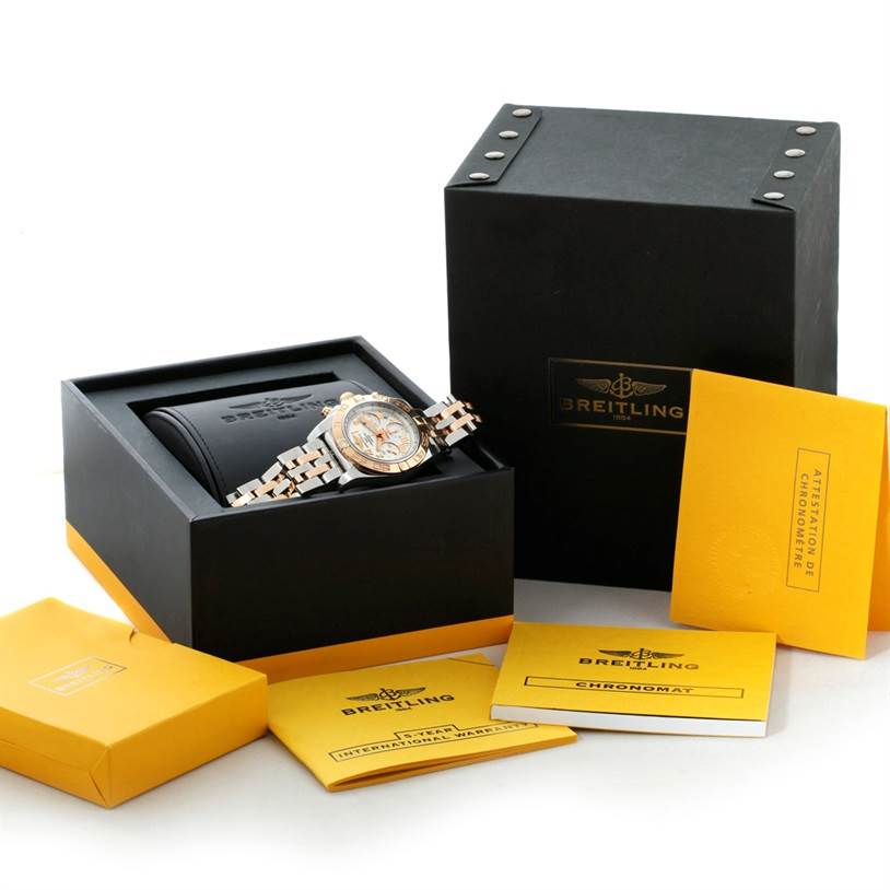 The image shows a Breitling Chronomat CB0140 Men's Steel and Gold (two tone) White Dial CB0140 Men's Steel and Gold (two tone) White Dial watch in its box with accompanying accessories, manuals, and papers from a front angle.