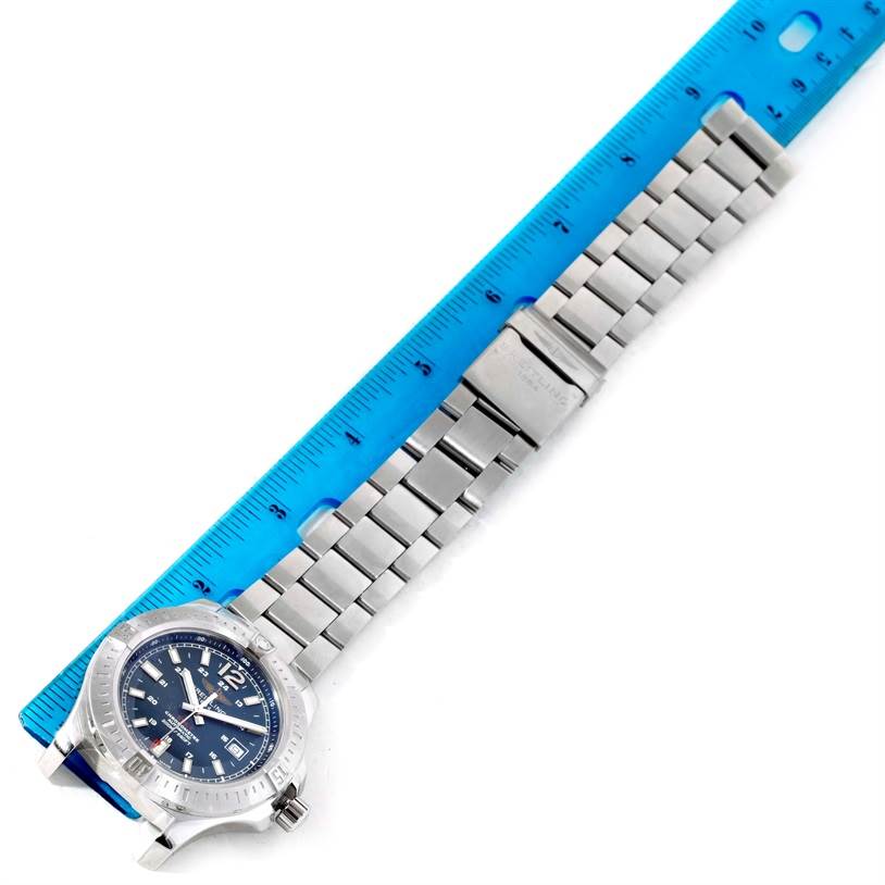 This image shows a Breitling Colt A17388 Men
s Stainless Steel Blue Dial A17388 Men
s Stainless Steel Blue Dial watch at an angled view, highlighting its dial, case, and metal watch band alongside a ruler.
