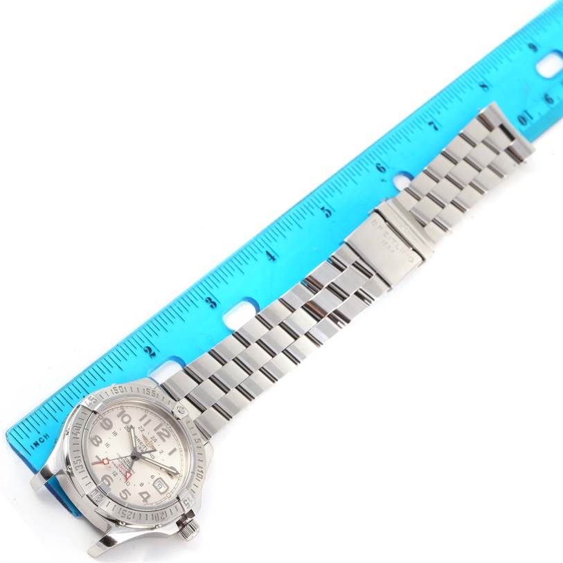 The image displays the Breitling Colt A32350 Men's Stainless Steel Beige Dial A32350 Men's Stainless Steel Beige Dial watch laid flat next to a ruler, showing the watch case and metal bracelet in full length.