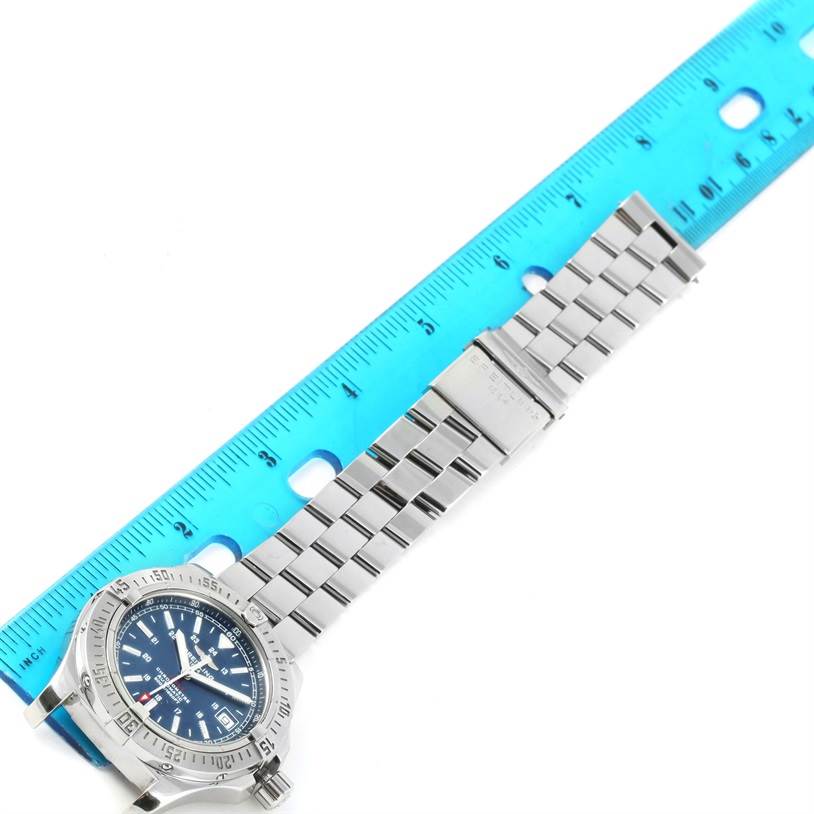 The image shows a Colt model by Breitling at an angle, displaying the face, stainless steel bracelet, and clasp alongside a ruler.