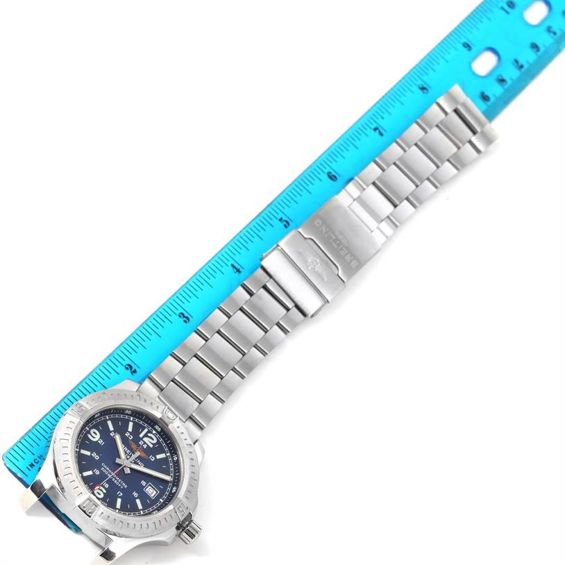The image shows a Breitling Colt A74388 Men
s Stainless Steel Blue Dial A74388 Men
s Stainless Steel Blue Dial watch laid flat next to a ruler, showcasing its bracelet and case from a top-down angle.