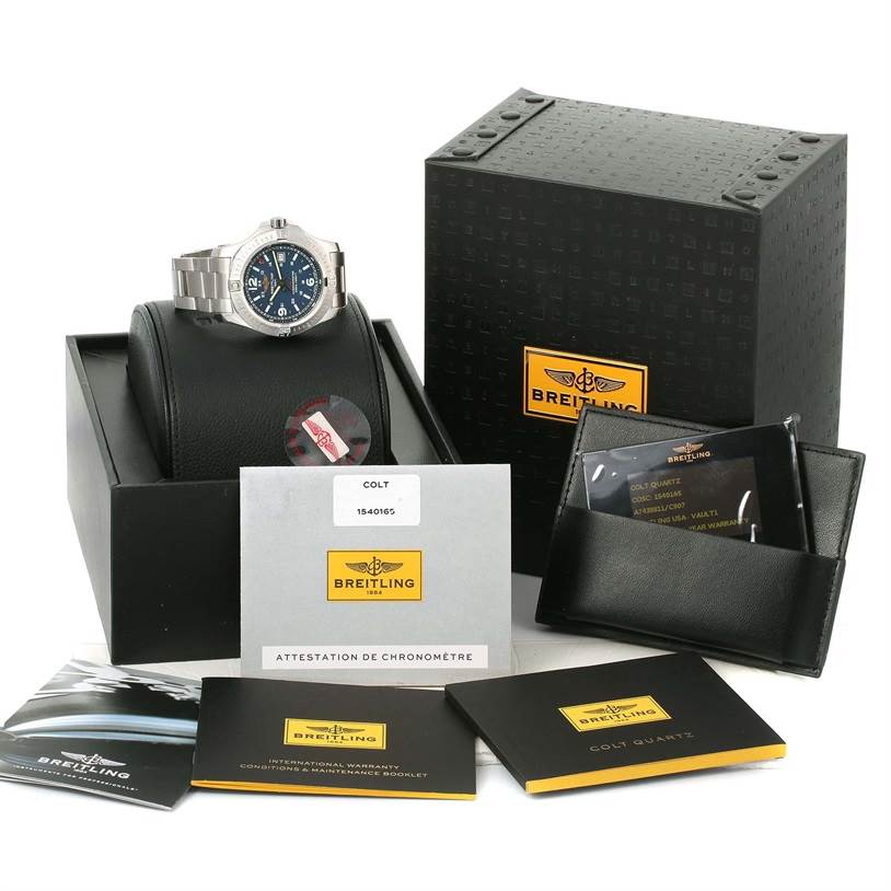 The Breitling Colt A74388 Men
s Stainless Steel Blue Dial A74388 Men
s Stainless Steel Blue Dial watch is displayed with its box, manuals, warranty card, and holder, all viewed from a slightly elevated angle.