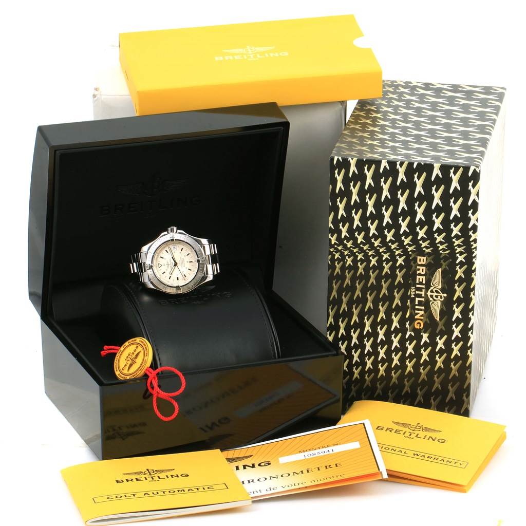 The image shows a Breitling Colt A17380 Men
s Stainless Steel Silver Dial A17380 Men
s Stainless Steel Silver Dial watch in its box with warranty cards and packaging.