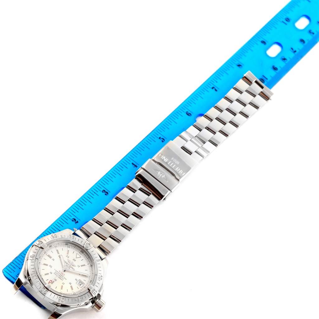 The image shows a Breitling Colt A17380 Men
s Stainless Steel Silver Dial A17380 Men
s Stainless Steel Silver Dial watch laid flat next to a blue ruler, with emphasis on the watch face and metal bracelet.