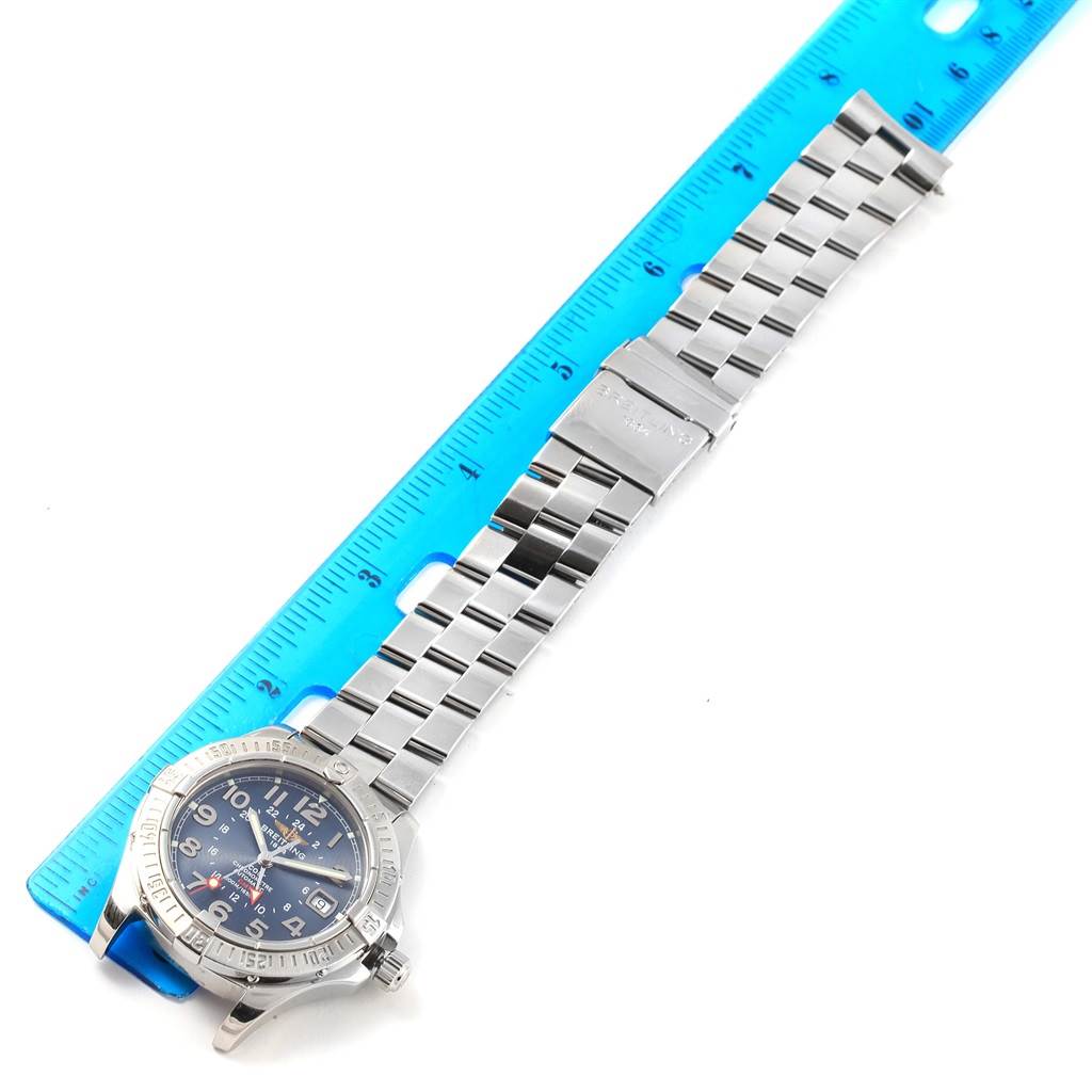 The image shows a Breitling Colt A32350 Men's Stainless Steel Blue Dial A32350 Men's Stainless Steel Blue Dial watch laid flat next to a ruler, displaying the watch face and the stainless steel bracelet.